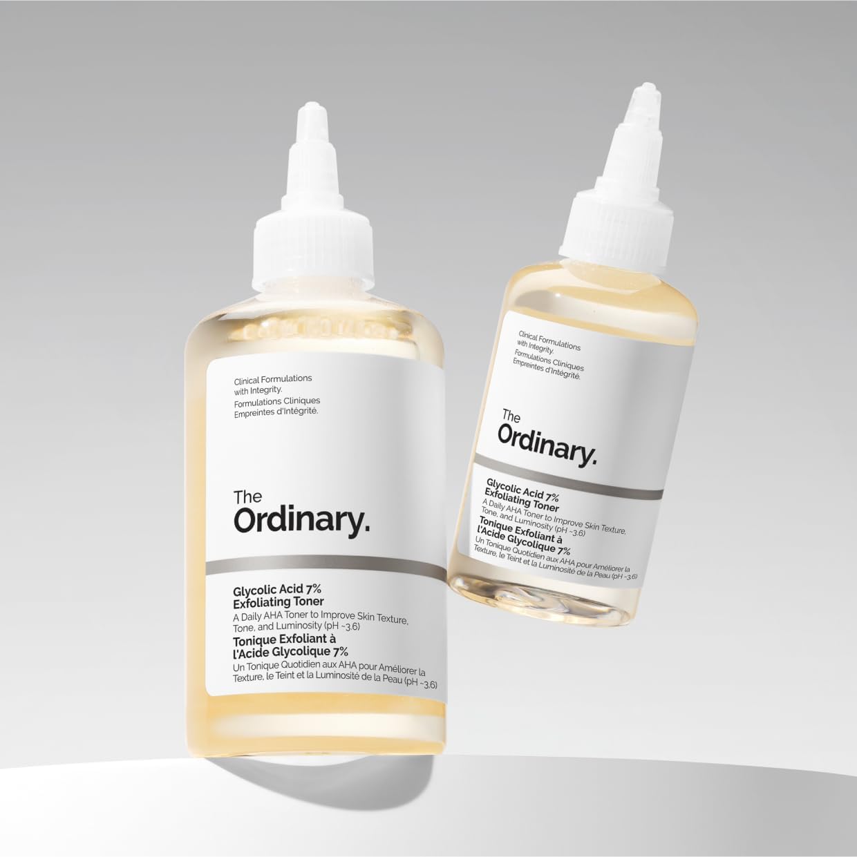 Two bottles of 'The Ordinary' toner on a gray background